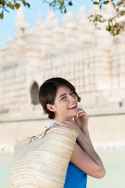 Mujer feliz llevando una bolsa de compras de paja —  Fotos de Stock