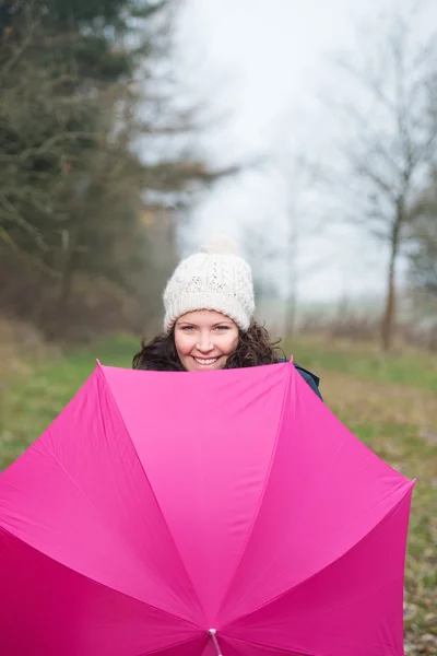 Jovem mulher com guarda-chuva rosa no parque — Fotografia de Stock