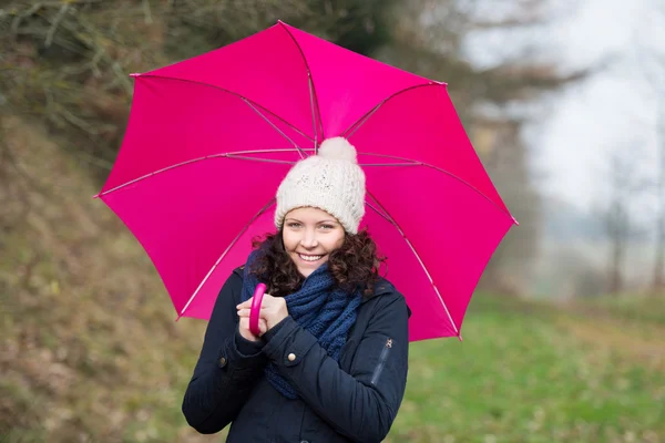 Walking under a pink umbrella — Stock Photo, Image