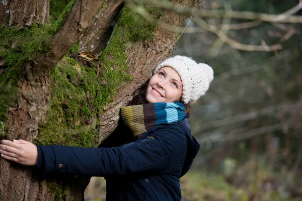 Donna in inverno Abbigliamento che abbraccia l'albero — Foto Stock