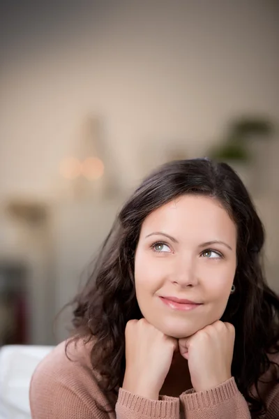 Pretty young woman daydreaming at home Stock Image