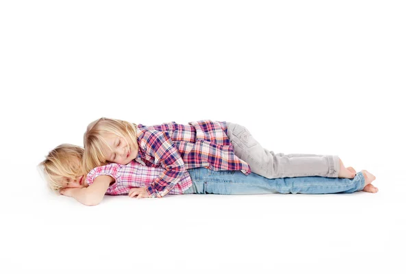 Lilla flickan liggande på syster mot vit bakgrund — Stockfoto