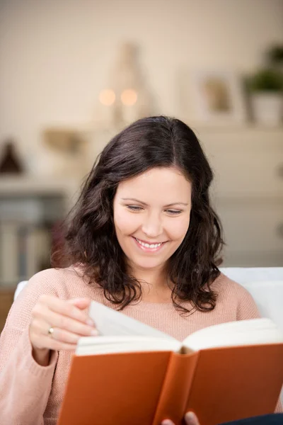 Mulher lendo um livro no sofá — Fotografia de Stock