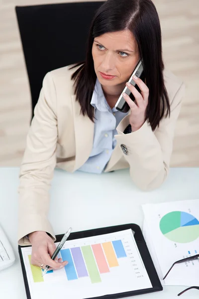 Mujer seria discutiendo un gráfico analítico — Foto de Stock