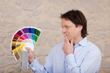 Man planning the colours of his new house clipart