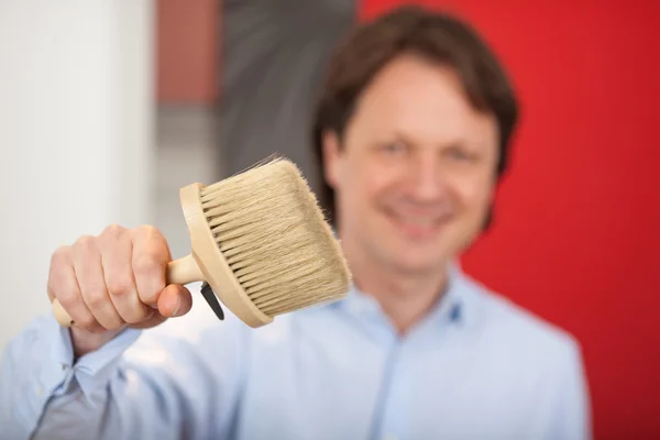 Smiling decorator with a paint brush