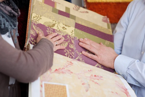 Mujer mirando muestras de papel pintado y tela — Foto de Stock