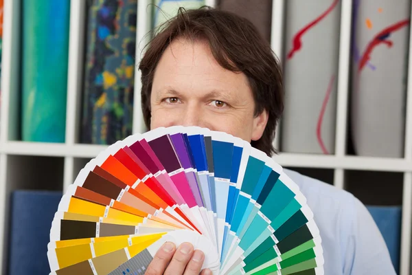 Man matching paint and carpet colours — Stock Photo, Image