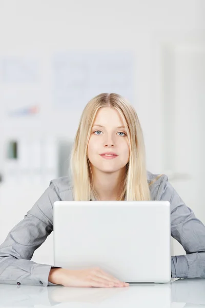Jovem mulher trabalhando em um computador portátil — Fotografia de Stock