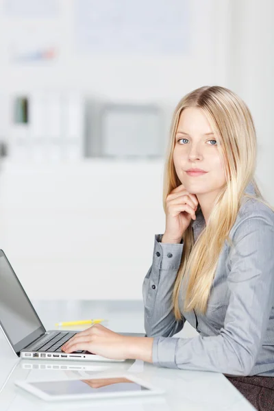 Affidabile donna d'affari che utilizza il computer portatile alla scrivania — Foto Stock