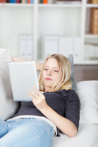 Jeune femme relaxante lisant un e-book — Photo
