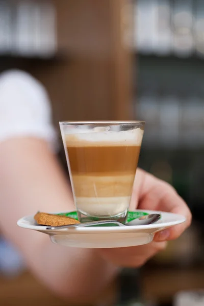 Kelnerka seving latte macchiato — Zdjęcie stockowe