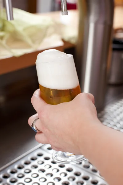Frothy head on a pint of draft beer — Stock Photo, Image