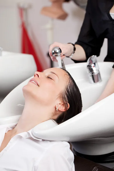 Hairstylist giving a hair shampoo — Stock Photo, Image