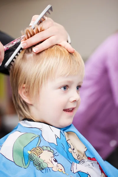 Lindo niño pequeño consiguiendo un corte de pelo — Foto de Stock