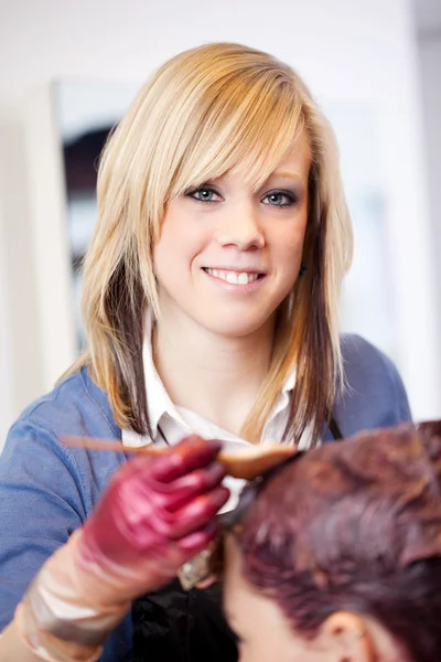 Uśmiechający się fryzjerka stosowania odcień — Zdjęcie stockowe