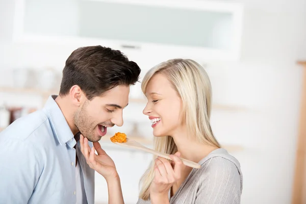 Mujer alimentación de alimentos para el hombre en la cocina — Foto de Stock