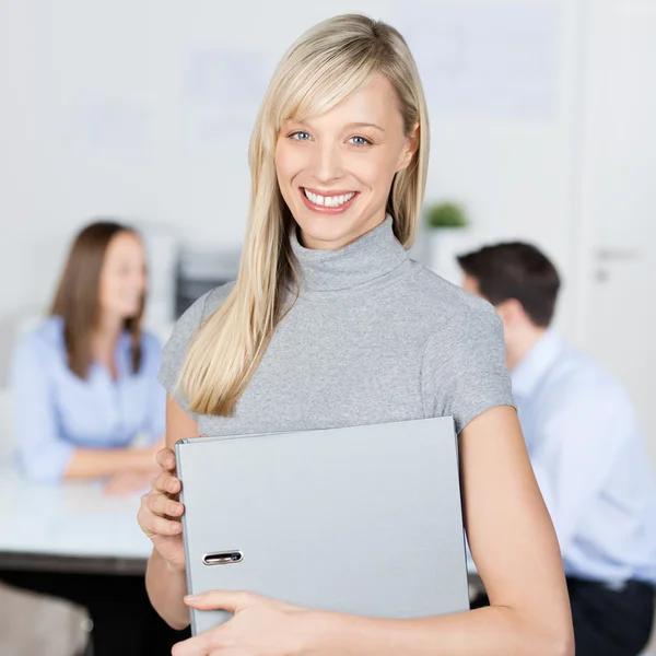 Businesswoman Holding Binder With Coworkers In Background — Stock Photo, Image