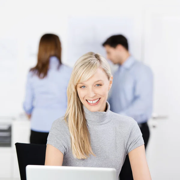 Confident Businesswoman Smiling With Colleagues In Background Stock Image