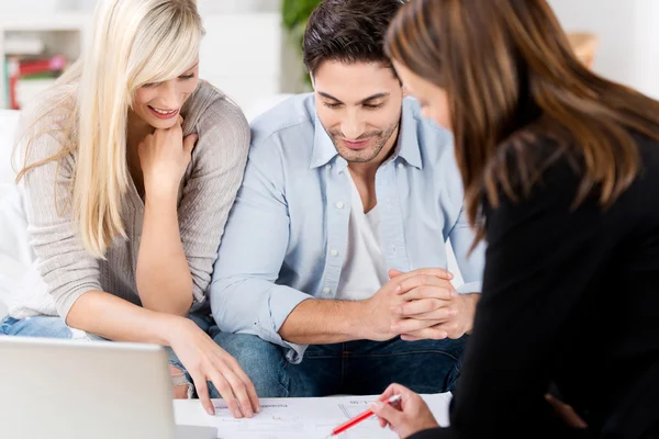 Conseiller financier expliquant le document au couple à la table Images De Stock Libres De Droits