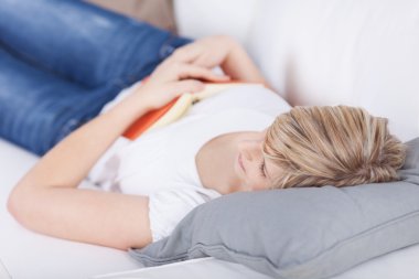 Woman falling asleep while reading clipart