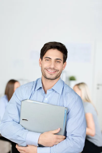 Zakenman houden binder met collega's op achtergrond — Stockfoto