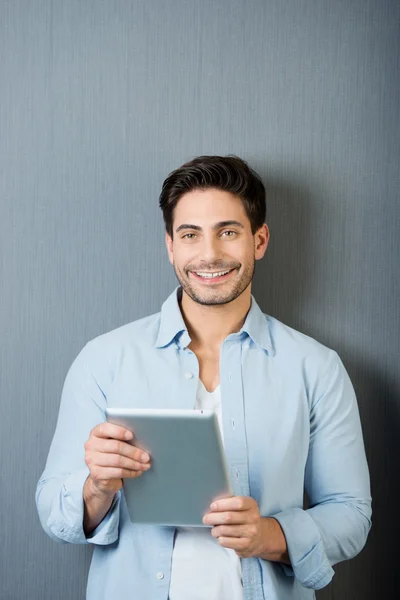 Hombre sosteniendo la tableta digital contra la pared azul —  Fotos de Stock