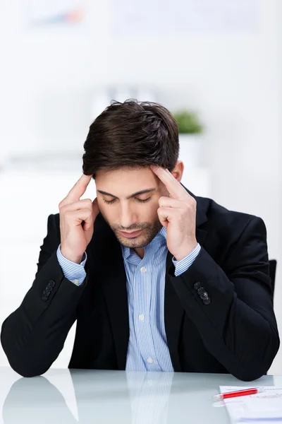 Geschäftsmann leidet unter Kopfschmerzen am Schreibtisch — Stockfoto