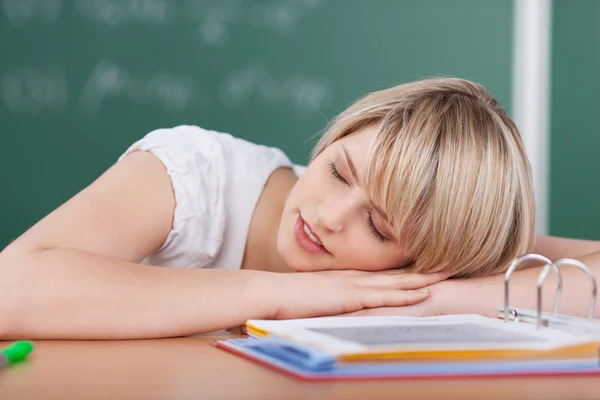 Уставшая юная студентка спит на книгах — стоковое фото