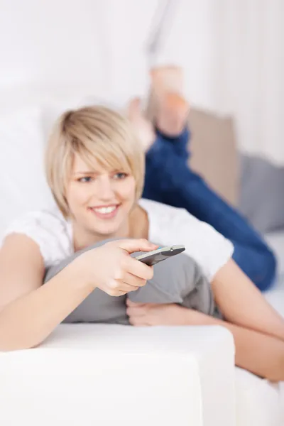 Blond woman with remote control — Stock Photo, Image