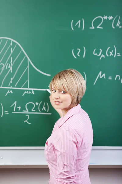 Student or teacher writing on the blackboard — Stock Photo, Image