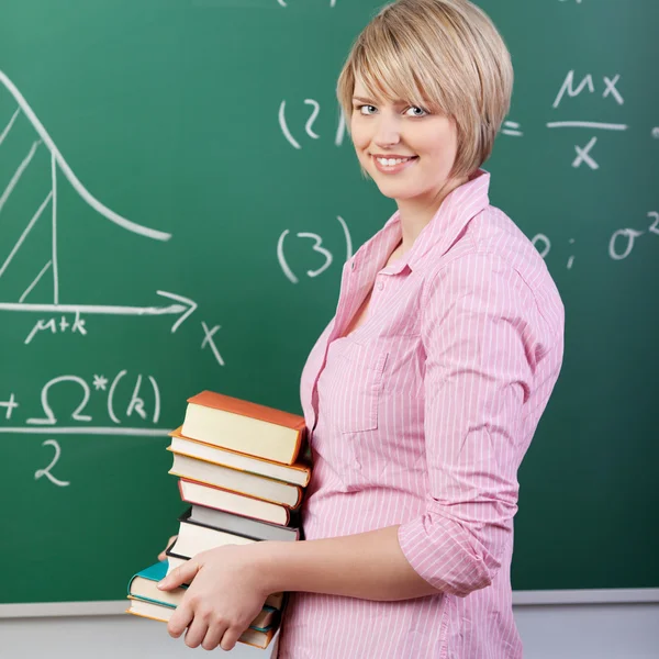 Estudiante bastante femenina llevando libros en clase — Foto de Stock