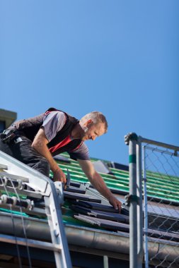 Roofer assembling roof tiles clipart