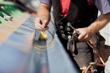 Close-up of a roofer welding the gutter clipart