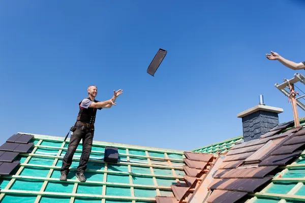 Two roofers tossing tiles — Stock Photo, Image