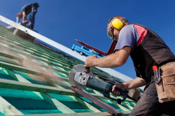 Roofer using a hand circular saw — Stock Photo, Image