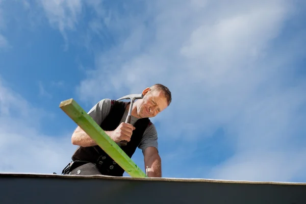 Dachdecker hämmert einen Nagel — Stockfoto