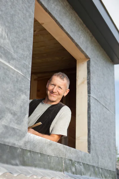 Porträtt av en takläggare som söker av ett VINDSKUPEFÖNSTER — Stockfoto
