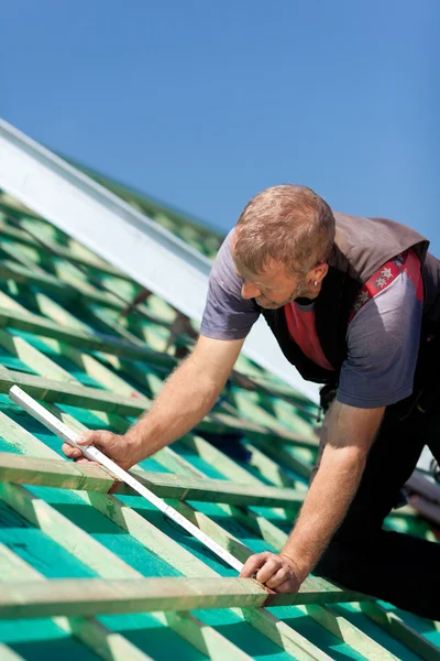 Roofer measuring the roof beams — Stock Image Roofer measuring the roof beams Royalty Free Stock Images