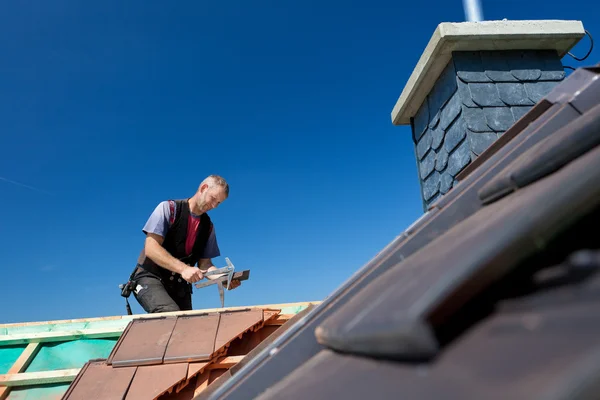 Roofer molding tiles with a hammer — Stock Image Roofer molding tiles with a hammer Royalty Free Stock Images