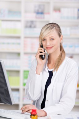 Friendly pharmacist portrait talking at the phone clipart