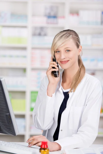 Friendly pharmacist portrait talking at the phone — Stock Photo, Image