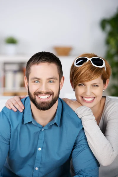 Junges Paar lächelt gemeinsam im Haus — Stockfoto