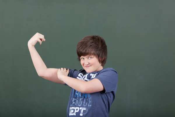Schattige jonge jongen pronken zijn biceps — Stockfoto