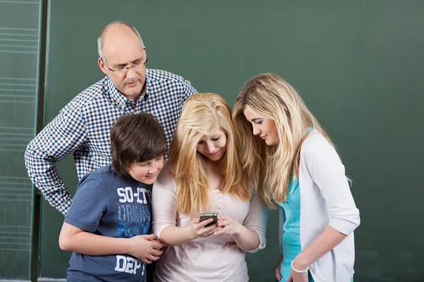 Schoolkinderen spelen met een mobiele telefoon — Stockfoto