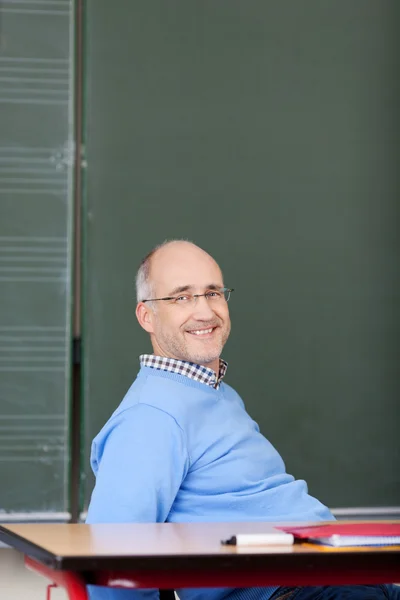 Sorrindo professor do sexo masculino relaxante na sala de aula — Fotografia de Stock