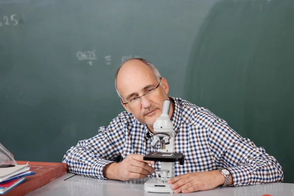 Lehrer schaut aufs Mikroskop — Stockfoto