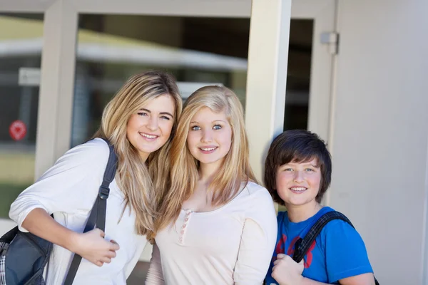 Three young students in front of the school — Stock Photo, Image