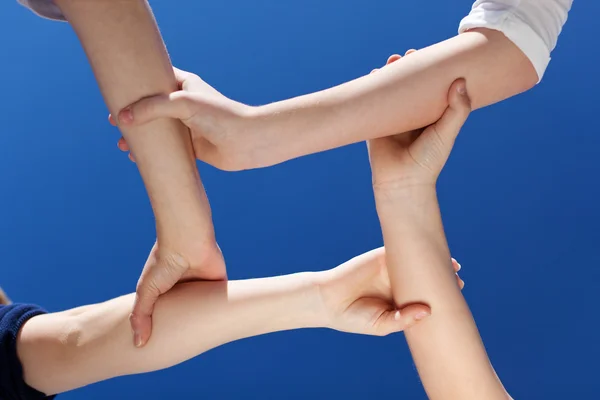 Closeup Of Friends Holding Hands Against Clear Blue Sky — Stock Photo, Image