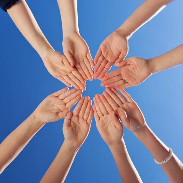 Students And Teacher 's Hands Together Against Blue Sky — стоковое фото